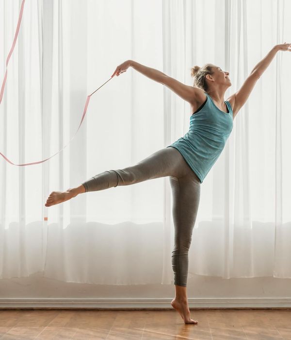 Active woman performing rhythmic exercises in a modern studio environment.